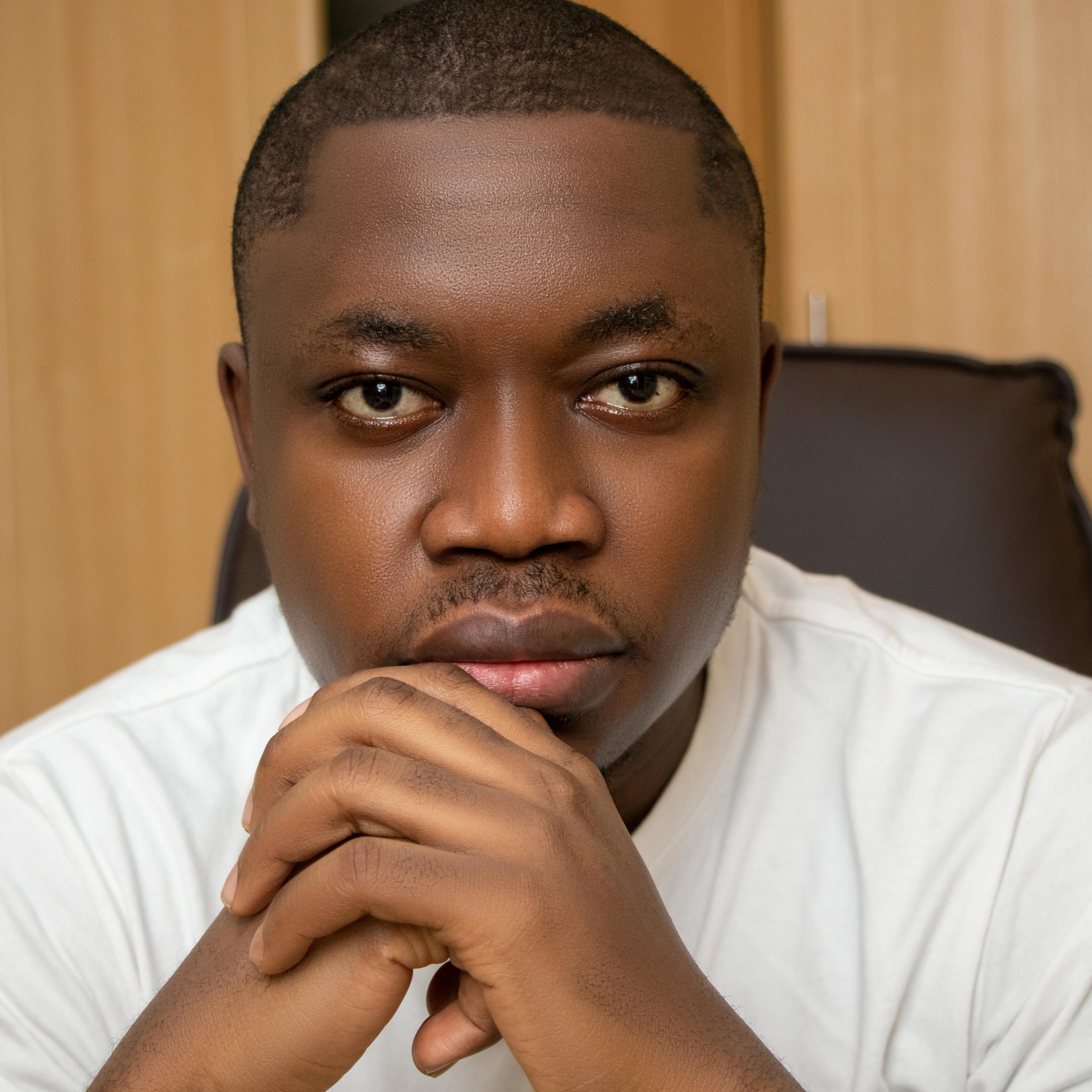Close-up portrait of an adult man in a thoughtful pose indoors.